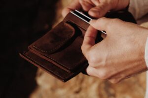 man holding leather wallet